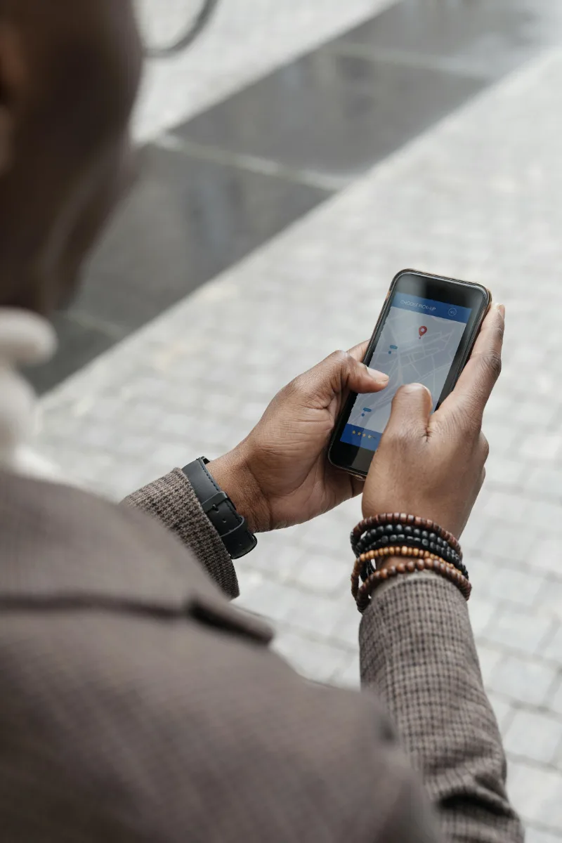 A person holding a phone in her hand and looking at the google maps.