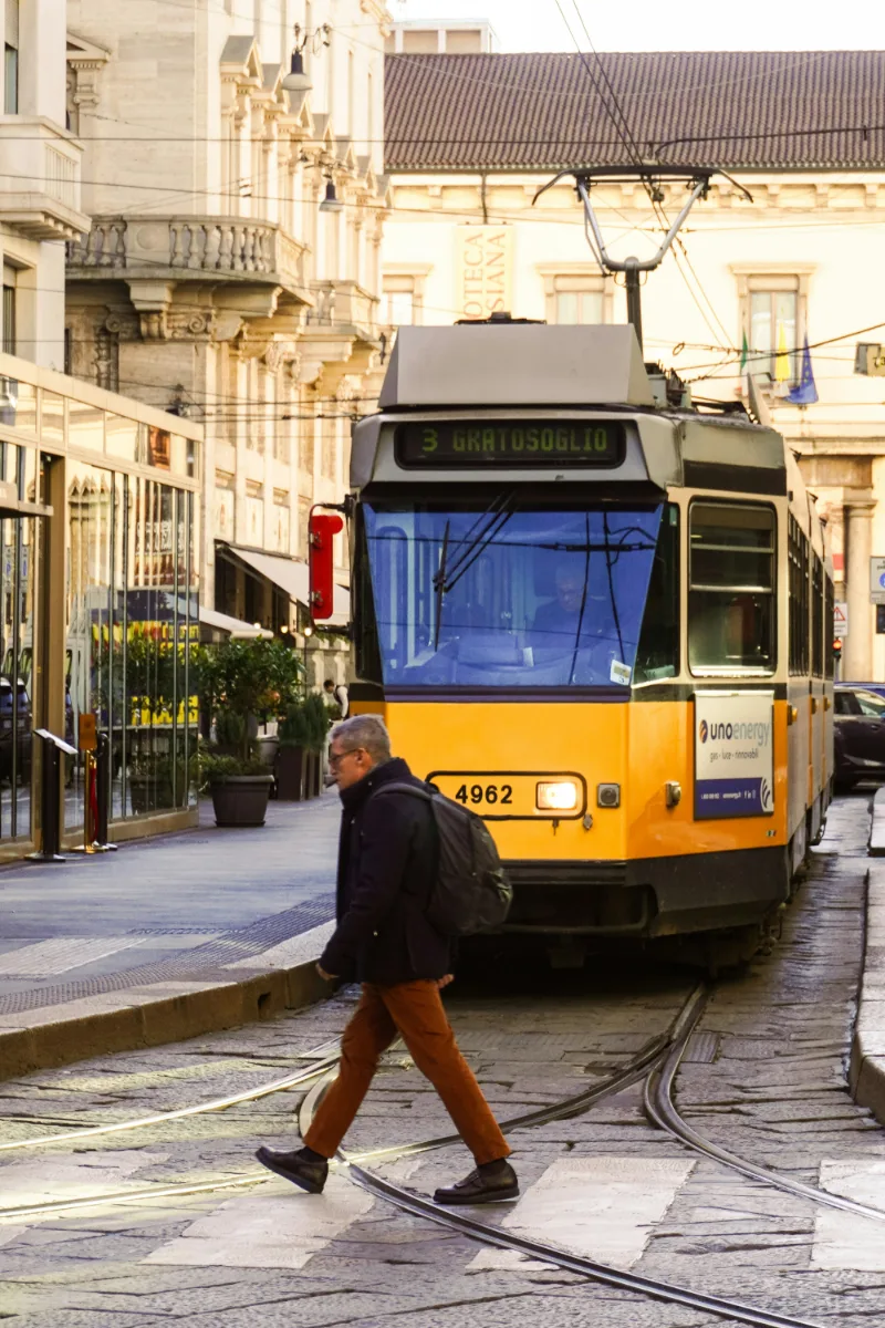 a person with a backpack crossing the tram rail in Italy.