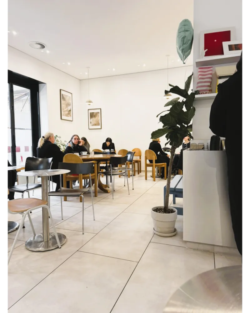 Bright café interior in Frankfurt with spacious tables, calm atmosphere, and a laptop-friendly setup for working.