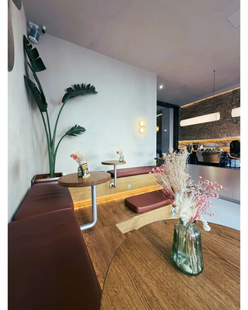 Bright café interior in Frankfurt with spacious tables, calm atmosphere, and a laptop-friendly setup for working.