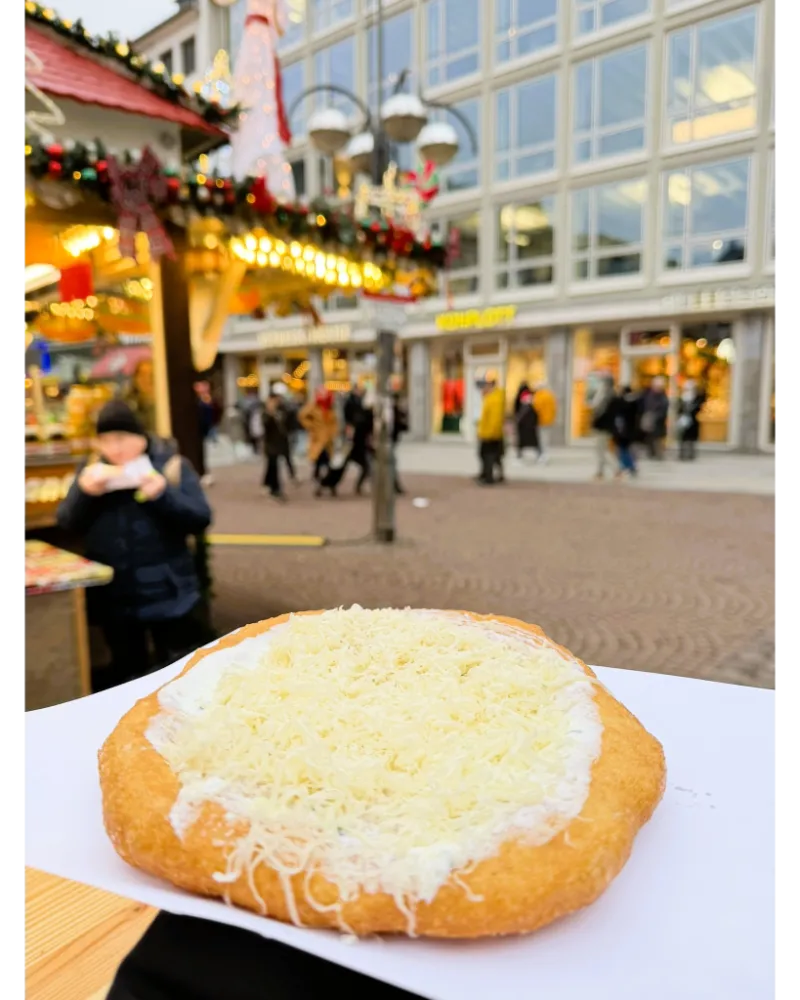 Crispy Langos topped with cheese and speck at the Frankfurt Christmas Market — one of the most popular savory treats.