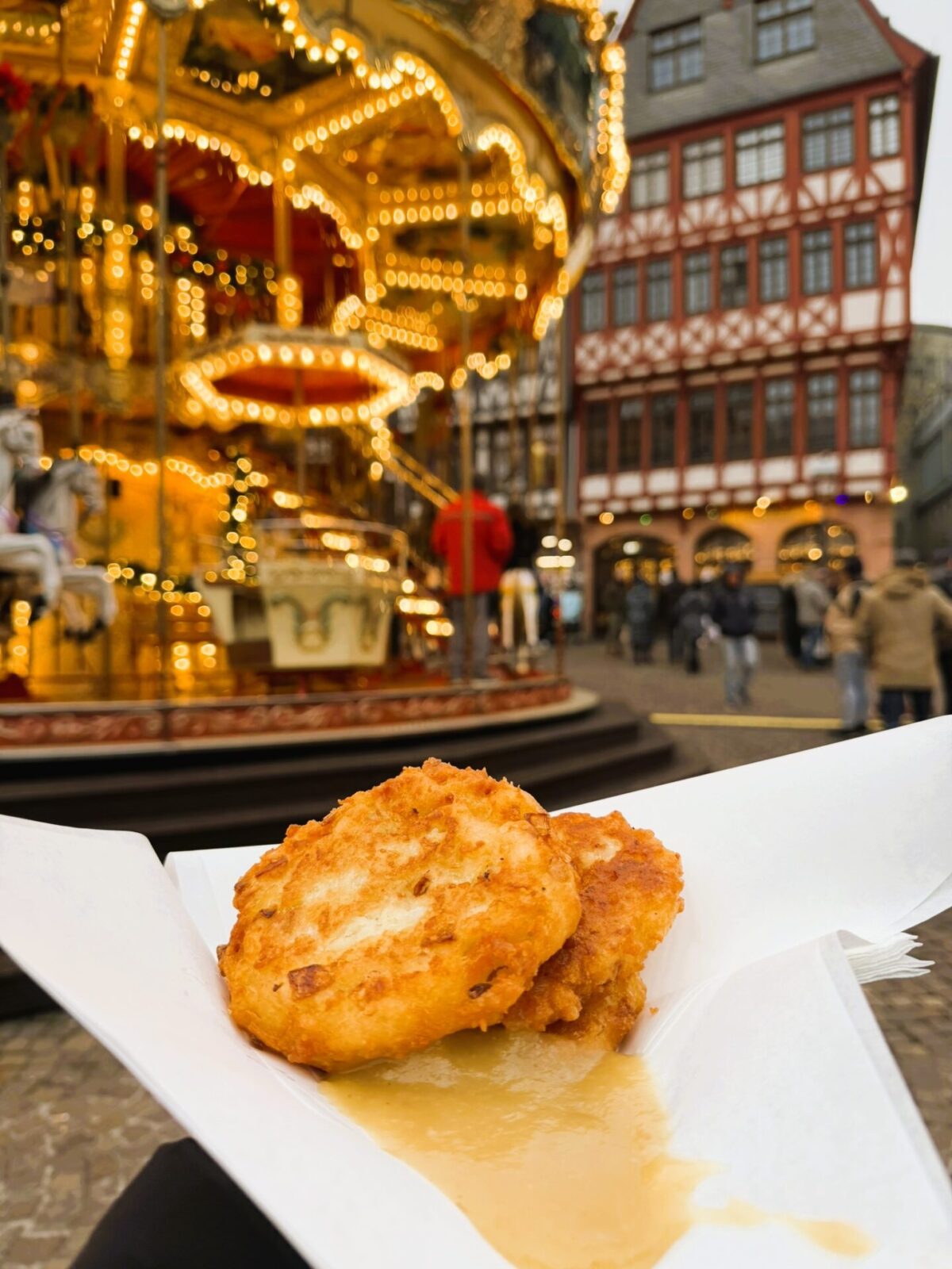 Traditional German Reibekuchen potato pancakes served hot at the Frankfurt Christmas Market, usually paired with applesauce.