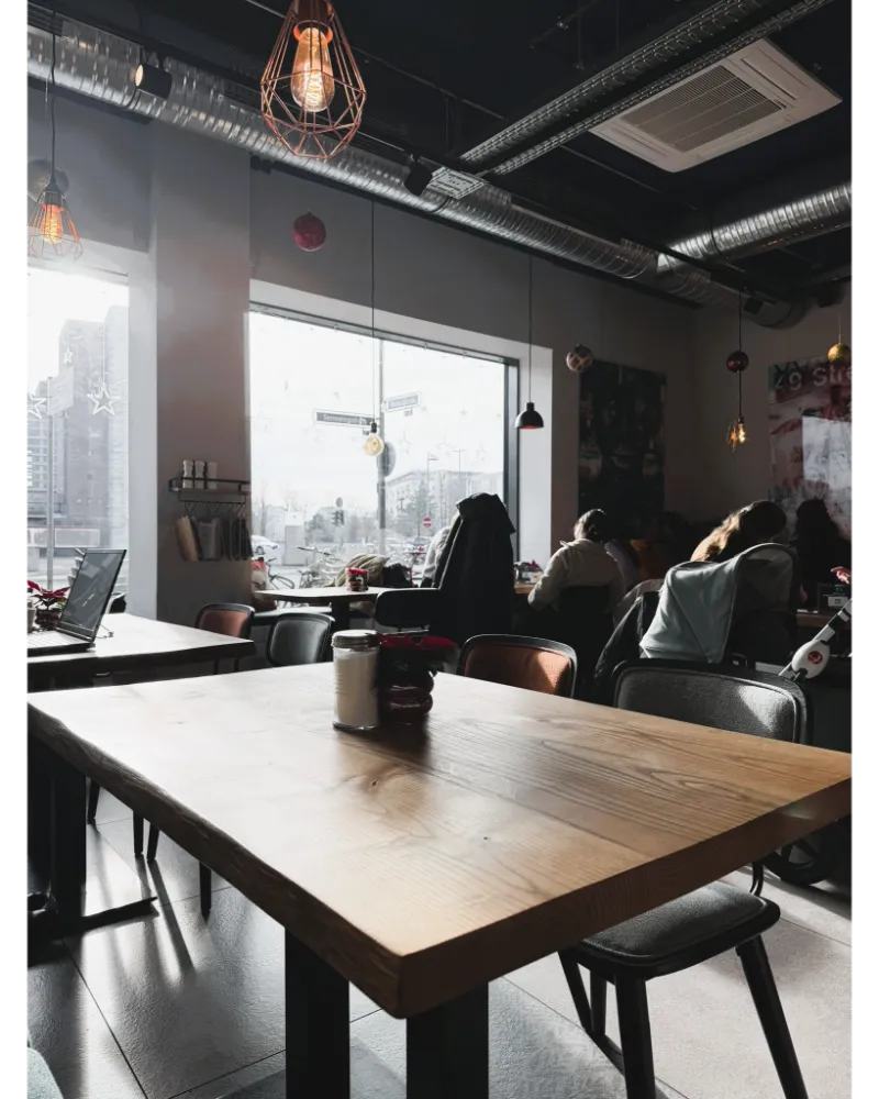Modern café interior in Frankfurt with minimalist design, coffee, and laptops, popular among remote workers.