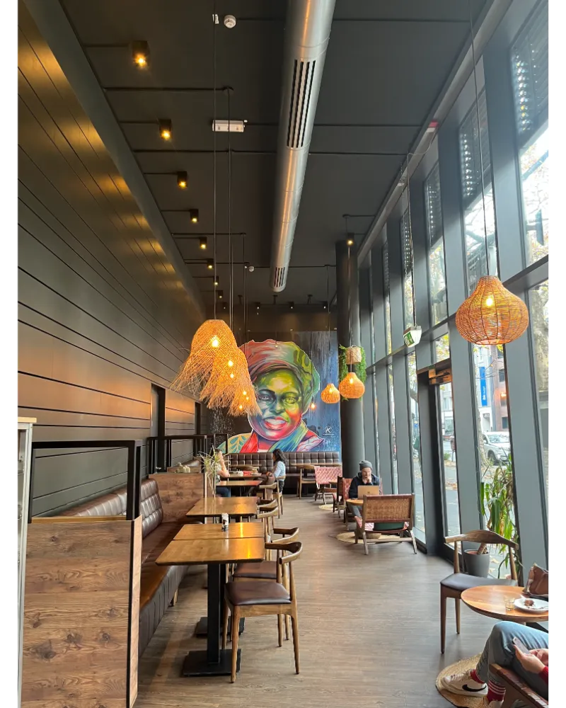 Modern café interior in Frankfurt with minimalist design, coffee, and laptops, popular among remote workers.