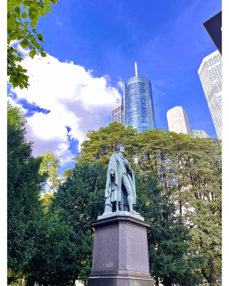 Taunusanlage park in Frankfurt with greenery and skyscrapers in the background.